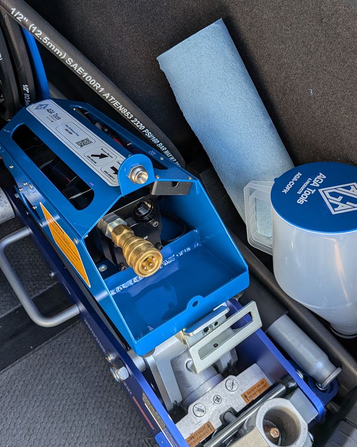 Blue waste oil pump with its hose fitting, in our service vehicle.