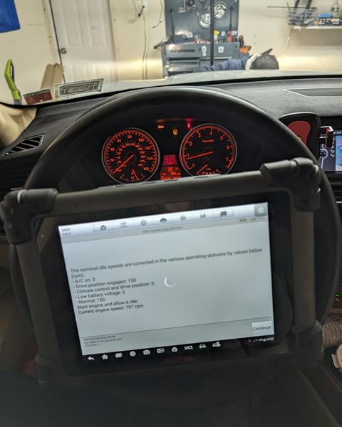 Diagnostic scan tablet mounted on the steering wheel during a calibration.