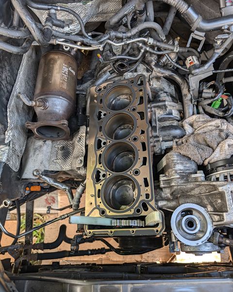 Engine with the cylinder head removed, showing the cylinders and head gasket surface.